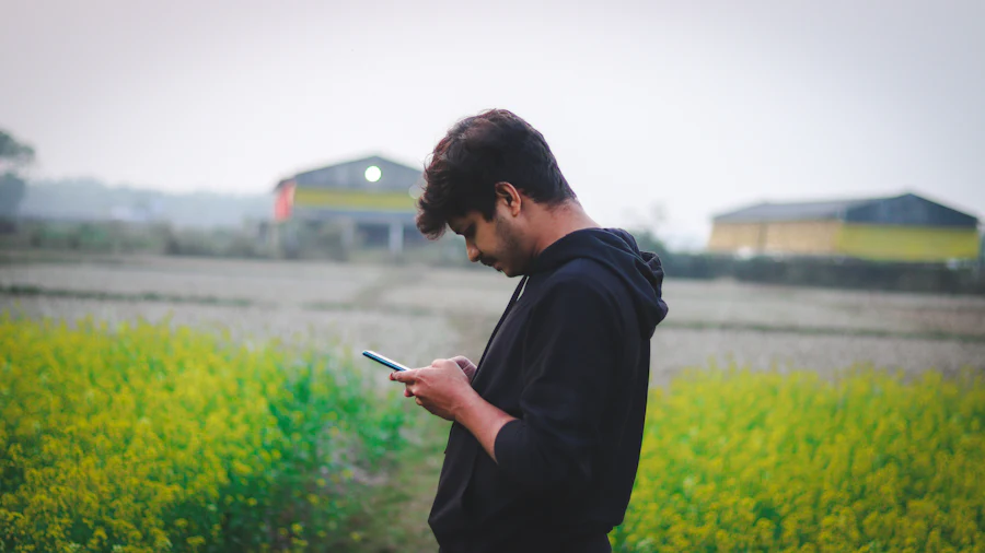 Farmer checking a connected device in a field, representing IoT-enabled agriculture