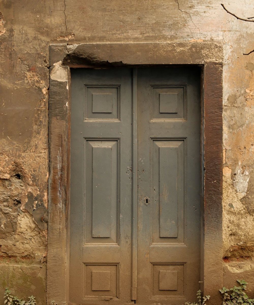 An old grey double door set in a stone frame